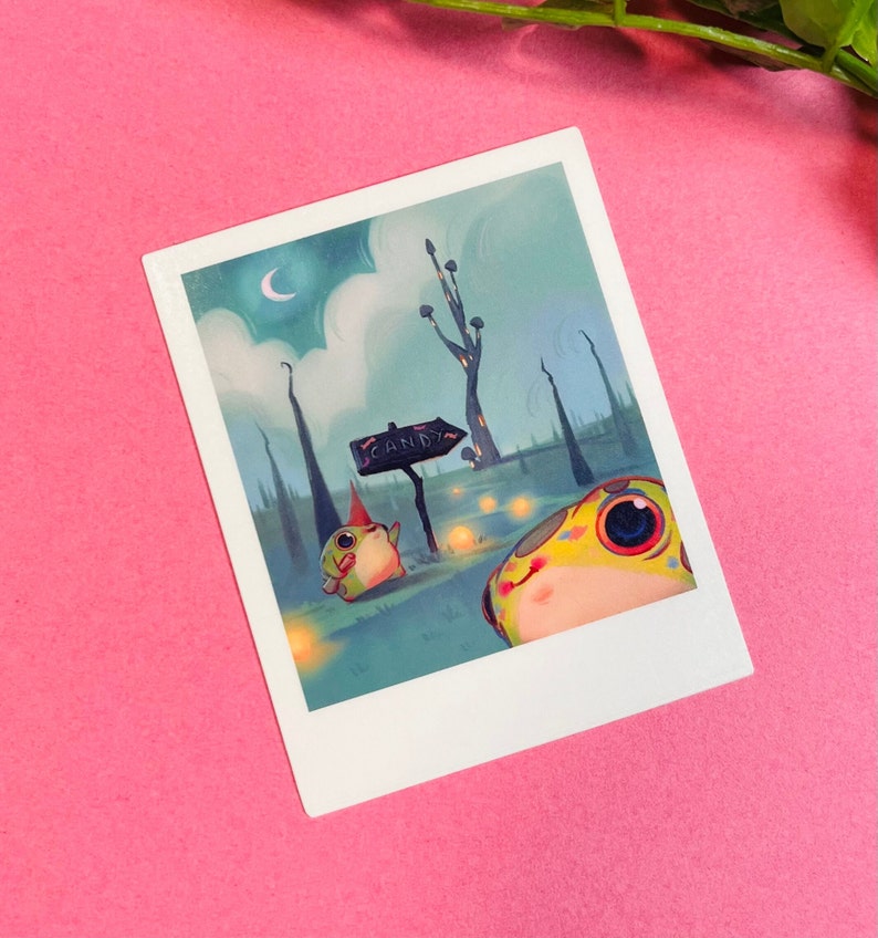 May include: A whimsical illustration of two frog-like creatures in a forest setting. One frog is wearing a pointed hat and the other is looking up at a sign that reads "CANDY". The background is a blue-green color with a crescent moon in the sky.