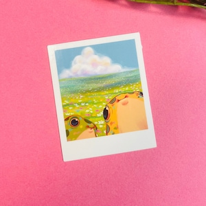 May include: A whimsical illustration of two frogs looking up at a fluffy white cloud in a blue sky. The frogs are green and yellow with black spots and are surrounded by a field of colorful flowers.