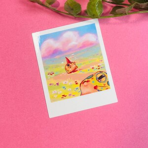 May include: A colorful illustration of two cartoon frogs in a field of flowers. The frog in the foreground is looking up at the sky, while the frog in the background is wearing a party hat and looking towards the horizon. The sky is a soft pink and blue with fluffy clouds.