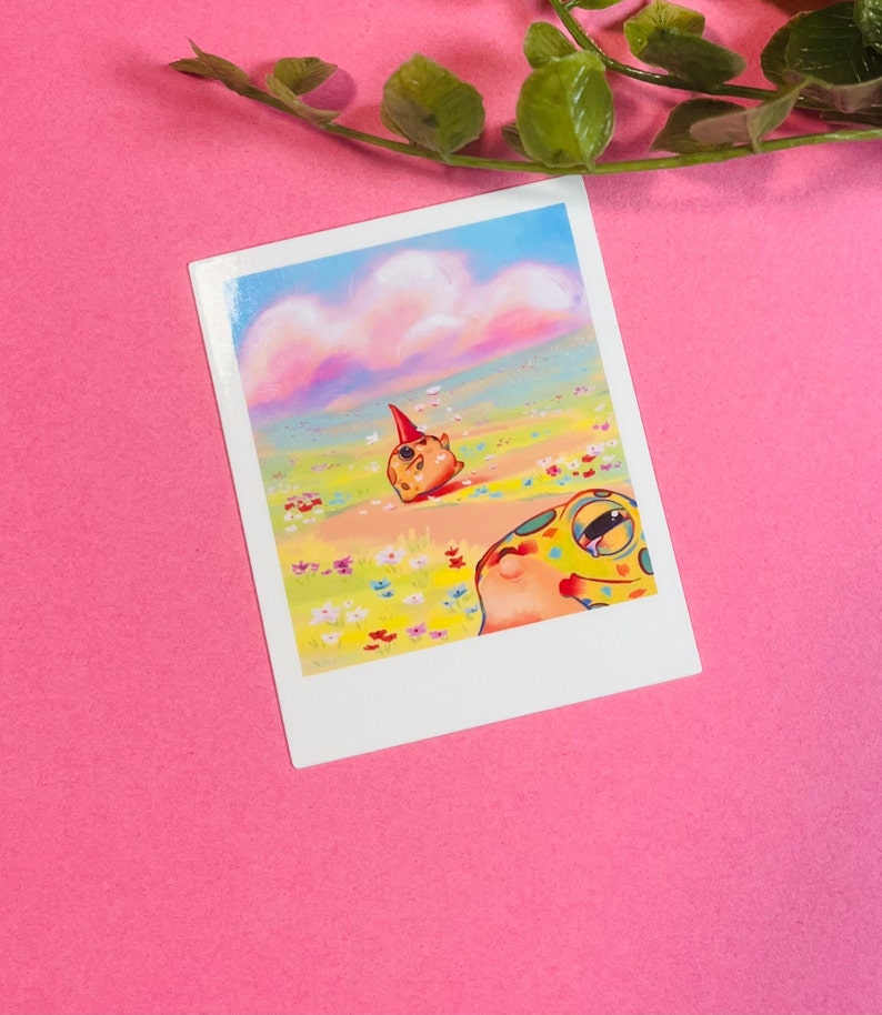 May include: A colorful illustration of two cartoon frogs in a field of flowers. The frog in the foreground is looking up at the sky, while the frog in the background is wearing a party hat and looking towards the horizon. The sky is a soft pink and blue with fluffy clouds.