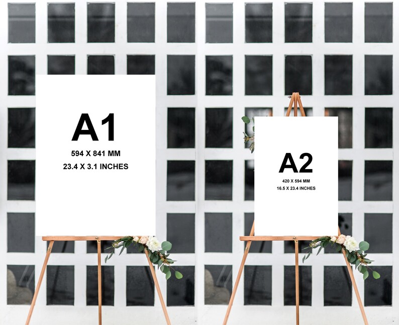 May include: Two white poster boards on easels with black text indicating the paper sizes A1 and A2. The A1 poster board measures 23.4 x 3.1 inches and the A2 poster board measures 16.5 x 23.4 inches. Both easels are decorated with white flowers.