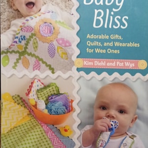 May include: A book cover with the title "Baby Bliss: Adorable Gifts, Quilts, and Wearables for Wee Ones" by Kim Diehl and Pat Wys. The cover features two babies, one holding a pacifier and the other wrapped in a colorful quilt.