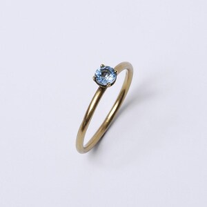 18K yellow gold ring with blue topaz – Round wire band – with a blue topaz image 2