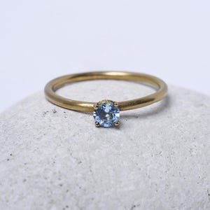 18K yellow gold ring with blue topaz – Round wire band – with a blue topaz image 1