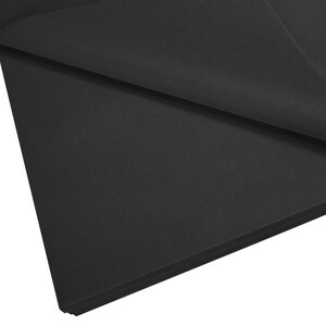 May include: A stack of black tissue paper. The paper is folded in half and the edges are visible.