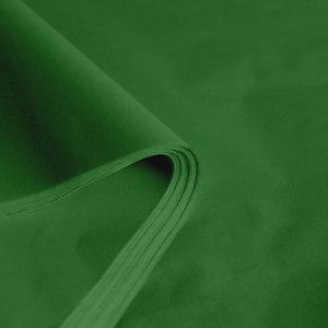 May include: Green tissue paper, folded in a stack, showing the texture and color of the paper.