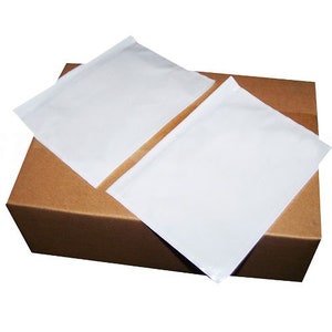 Puede incluir: Dos sobres acolchados blancos sobre una caja de cartón marrón.