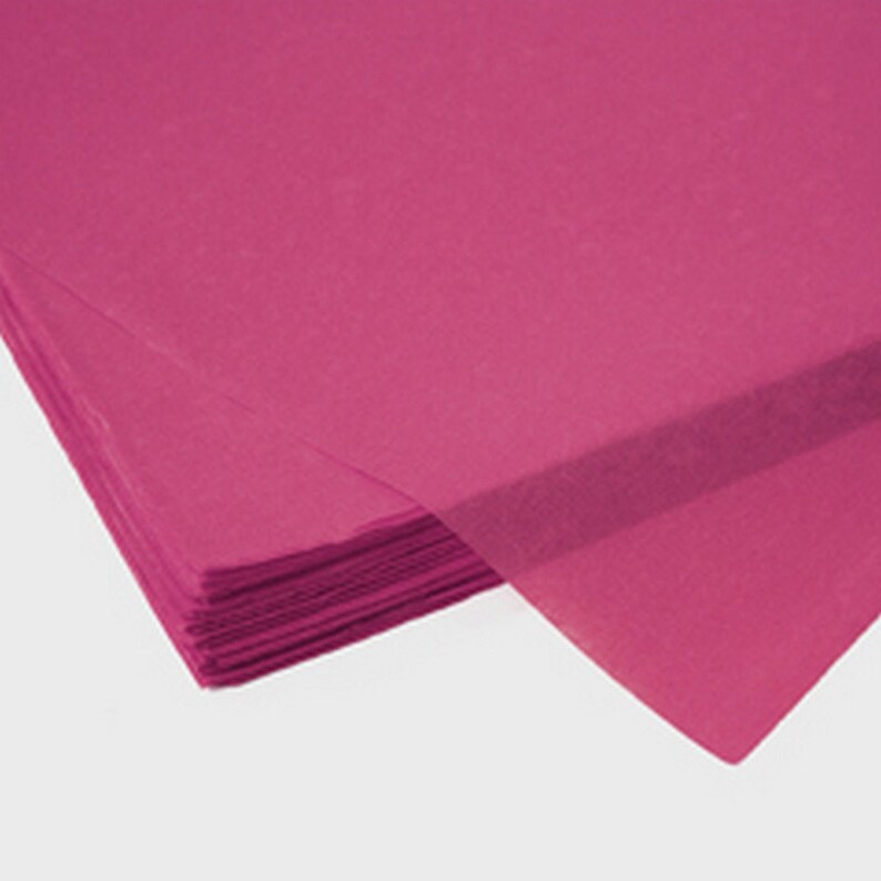 May include: A stack of bright pink tissue paper. The paper is folded and has a smooth, slightly translucent texture.