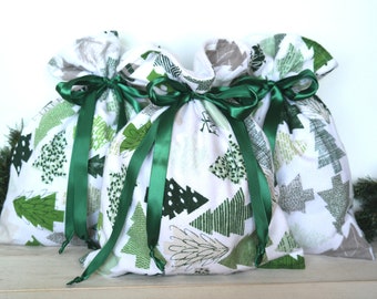 May include: Three white fabric gift bags with green Christmas tree designs and green satin ribbon ties.