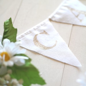 May include: White fabric banner with gold glitter letters spelling "Celebrate".