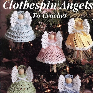 May include: Five crocheted angel ornaments in various colors, including blue, yellow, pink, green, and light blue, hanging on a Christmas tree. The angels are made with white yarn and have wooden clothespin bodies. The title "Clothes pin Angels To Crochet" is at the top of the image.