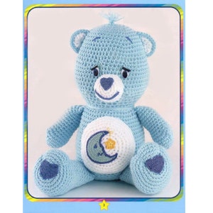 May include: A crocheted blue teddy bear with a white belly and a crescent moon and star design. The bear has a blue nose and blue eyes.