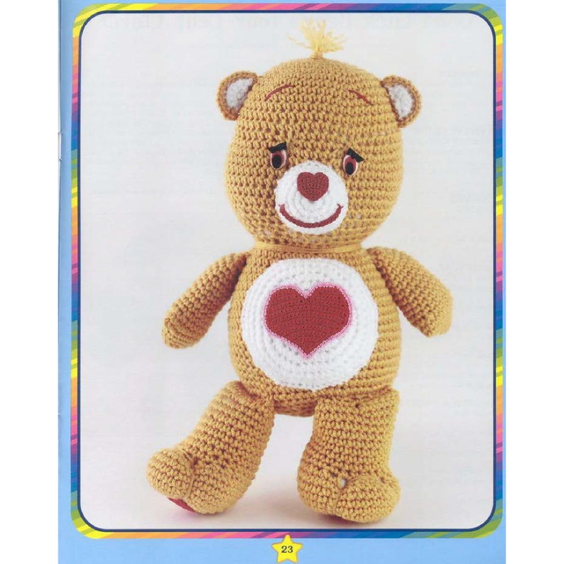 May include: A crocheted Care Bear plush toy with a brown body, white belly, and a red heart on its chest. The bear has a pink nose and a yellow bow on its head.