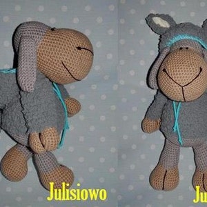 Puede incluir: Un juguete de peluche de oveja gris tejido a crochet con una chaqueta con capucha azul y orejas blancas. El juguete está de pie sobre un fondo azul y blanco de lunares. El texto "Julisiwo" es visible en la imagen.