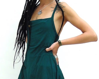 May include: A dark teal tunic top with a square neckline and an asymmetrical hemline. The top has thin straps and a button detail on the back. The model is wearing black leggings. The top is made of a soft, flowing fabric.