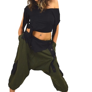 May include: A woman wearing a black crop top with a gold headpiece and olive green trousers with a button closure. The trousers have a black trim and a cargo pocket on the left leg.