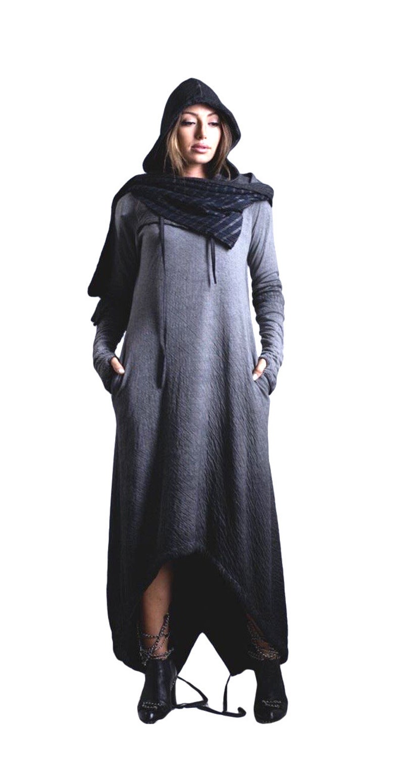 Puede incluir: Un vestido largo con capucha gris con mangas largas y bolsillos. El vestido tiene una tela texturizada y un dobladillo alto-bajo. Se usa una bufanda y una capucha negras con el vestido. La modelo lleva botines negros.