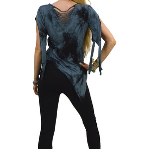 May include: A tie-dye asymmetrical top in shades of blue and black, featuring cut-out details on the back and sleeves. Paired with black leggings, this top offers a unique, edgy style. The back of the top has a series of horizontal cut-outs.