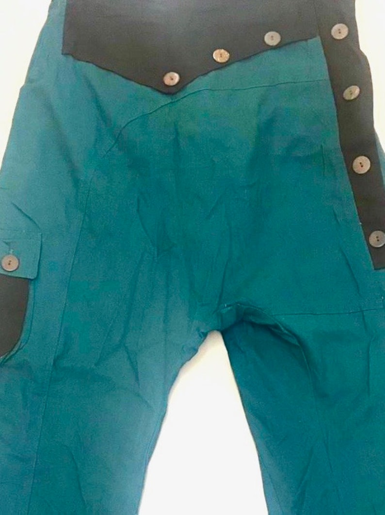 May include: Teal blue trousers with a black waistband and multiple brown buttons down the side.