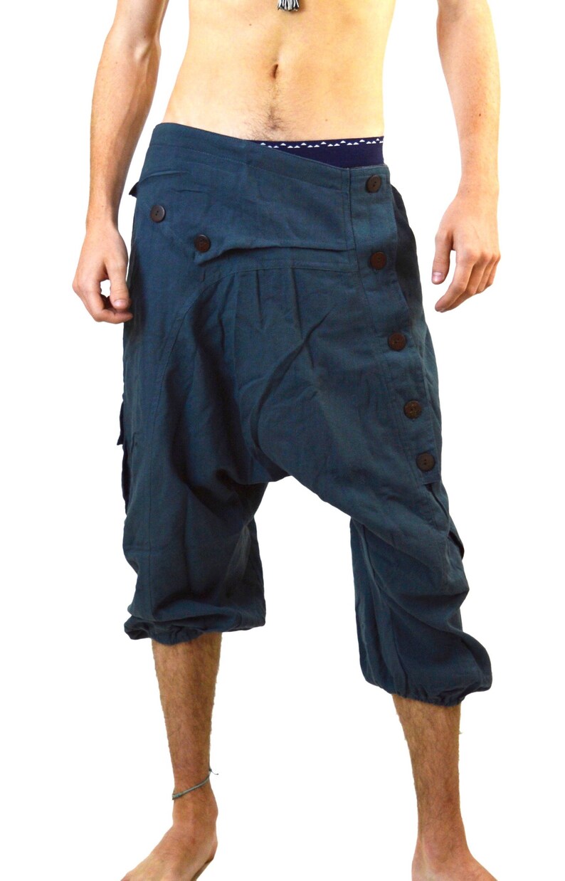 May include: A pair of dark blue, knee-length, loose-fitting trousers with a button fastening and a unique design.