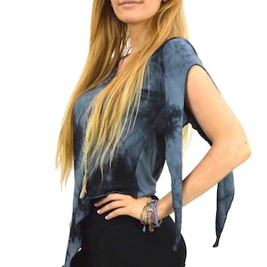 May include: A blue and black tie-dye top with long, flowing sleeves. The top is worn with black leggings. A woman is wearing the top and leggings. She is also wearing a bracelet.