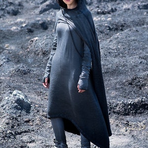 Puede incluir: Un vestido con capucha gris oscuro con una capa fluida, mangas largas y leggings a juego. El atuendo se completa con botas texturizadas. Este conjunto monocrom&aacute;tico es adecuado para cosplay o eventos de fantas&iacute;a.