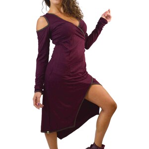May include: A burgundy wrap dress with long sleeves and a thigh-high slit. The dress features a V-neckline and cut-out shoulders. The dress is paired with matching burgundy high-top sneakers.