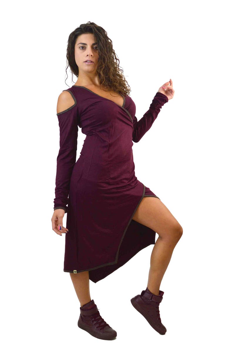May include: A burgundy wrap dress with long sleeves and a thigh-high slit. The dress features a V-neckline and cut-out shoulders. The dress is paired with matching burgundy high-top sneakers.