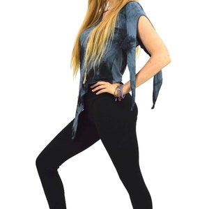May include: A woman wearing a tie-dye top and black leggings. The top is a dark blue with a flowing design, and the leggings are form-fitting. The woman is barefoot, with a bracelet on her wrist.