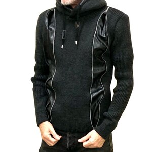 May include: Dark gray hooded sweater with black leather-like panels and silver zipper details. The sweater has a ribbed knit texture on the sleeves and lower body. The hood is lined with a contrasting material.