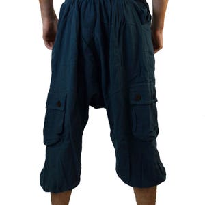 May include: Teal blue cargo shorts with a drawstring waist and two large pockets on the sides.