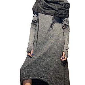Puede incluir: Un vestido largo gris con capucha y mangas largas. El vestido tiene un dobladillo alto-bajo y se combina con zapatillas negras. Una bufanda gris oscuro est&aacute; drapeada alrededor del cuello.