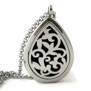 May include: A silver-toned teardrop-shaped pendant necklace featuring a cutout filigree design over a solid black background. The pendant is suspended from a matching silver-toned link chain, showcasing a polished metallic finish and intricate scrollwork patterns throughout the central cutout area.