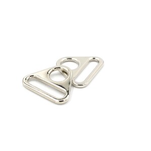 May include: Two silver triangle-shaped metal clasps with a small hole in the center of each triangle.
