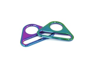 Puede incluir: Dos hebillas deslizantes de metal triangulares iridiscentes con un solo agujero y una barra plana. Las hebillas son una mezcla de azul, verde y morado.