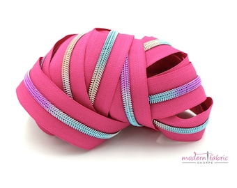 Nastro con cerniera rosa rossetto n. 5 con denti arcobaleno con tiretti a scelta, tagliati su misura. I tiretti unicorno sono perfetti con le borse Tula.