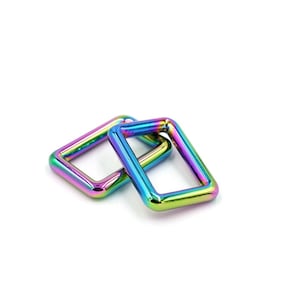 May include: Two iridescent metal D-rings, one stacked on top of the other. The rings are a rainbow of colours, including purple, blue, green, and yellow.