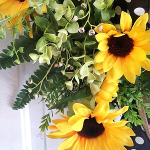 Detailed close‑up of mixed greenery and eucalyptus on grapevine wreath base.
