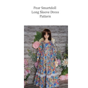 Puede incluir: Una muñeca con un vestido largo de manga larga con estampado floral. El vestido tiene un ribete de encaje blanco y una cinta blanca en la cintura. El texto dice "Pear Smartdoll Long Sleeve Dress Pattern" y "Pattern made by Sherryl Clayton of Bella's Doll Clothes."