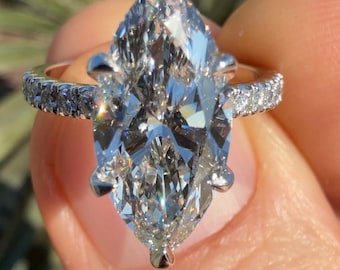 Könnte beinhalten: Ein Verlobungsring mit einem birnenförmigen Diamanten, der in einer Weißgoldfassung mit einer Pavé-Fassung sitzt.