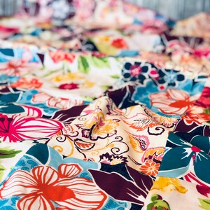 May include: A colorful patchwork quilt with a variety of floral patterns in shades of pink, blue, green, and yellow.