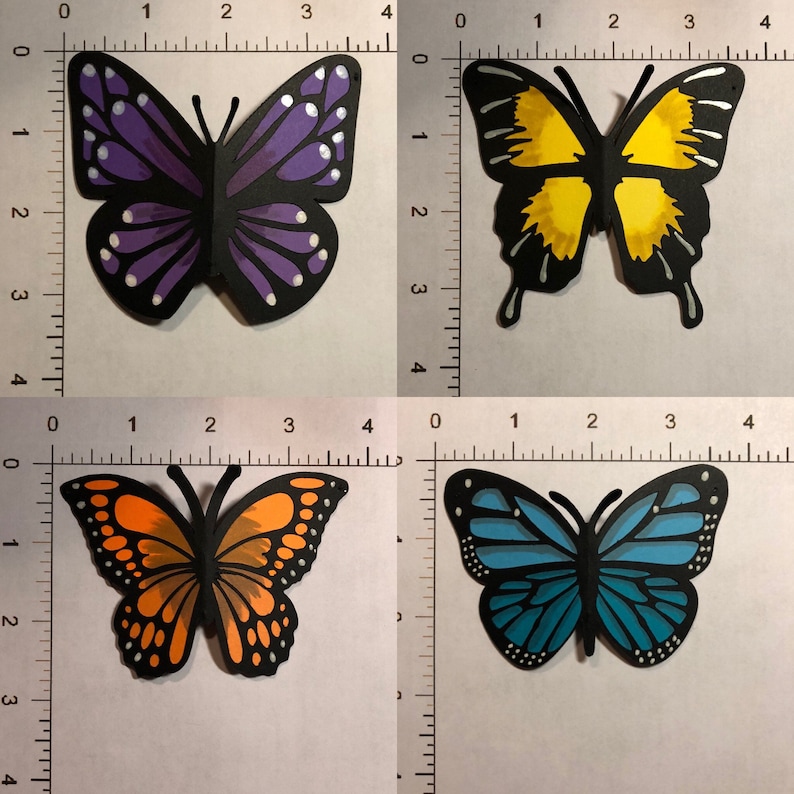 May include: Four colorful paper butterfly cutouts. One is purple with white accents, another is yellow, a third is orange, and the last is blue. Each butterfly is approximately 3 inches wide.