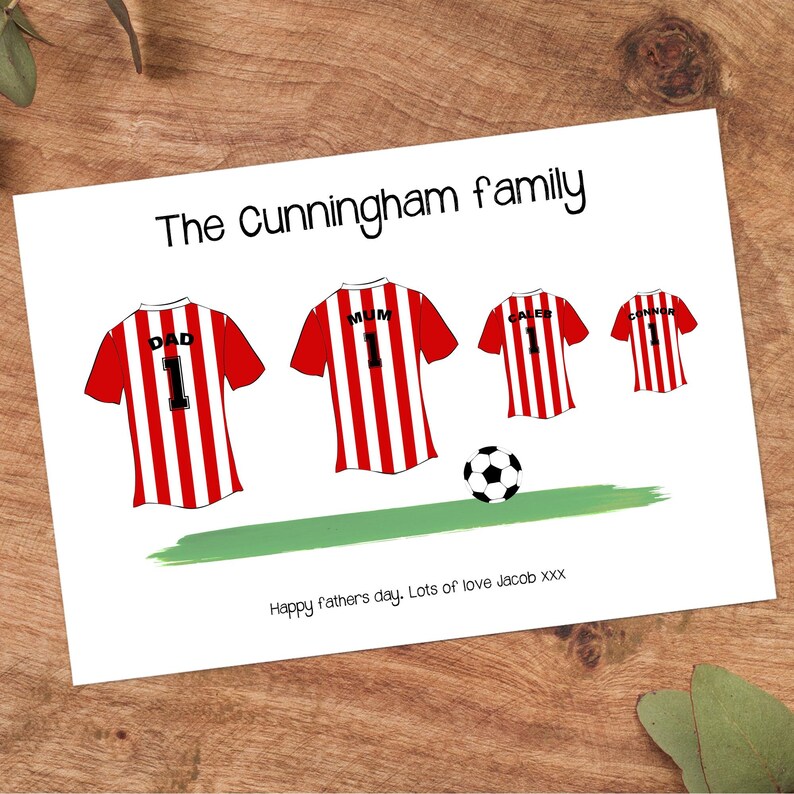 K&ouml;nnte beinhalten: Eine wei&szlig;e Karte mit dem Text "The Cunningham family" und Illustrationen von rot-wei&szlig; gestreiften Fu&szlig;balltrikots. Die Trikots sind mit "DAD", "MUM", "CALEB" und "CONNOR" beschriftet. Ein Fu&szlig;ball und ein gr&uuml;nes Feld sind ebenfalls abgebildet.