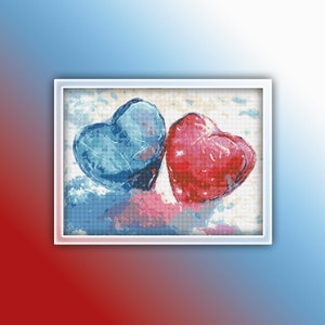 Könnte beinhalten: Zwei herzförmige Steine, einer blau und einer rot, liegen nebeneinander auf einem weißen Hintergrund. Die Steine sind mit einem Aquarell-Effekt bemalt.