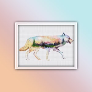 May include: A white wolf silhouette with a colorful landscape scene inside. The landscape features a mountain range, trees, and a sunset sky.