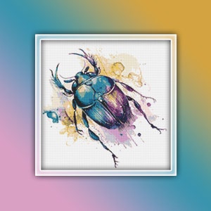 May include: A cross-stitch pattern depicting a beetle in shades of blue, purple, and gold. The insect features prominent horns and is set against a watercolour background with colourful splashes. The artwork is framed within a white square.