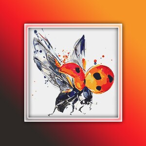 May include: A watercolor-style cross-stitch pattern of a bee. The bee features orange, red, and yellow accents, with black and blue wings. The design is set against a white background, framed in a white border.