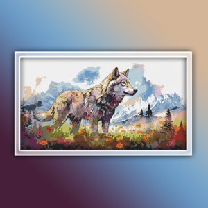 May include: A gray wolf stands in a field of colorful flowers with a mountain range in the background. The wolf is looking to the right of the image.