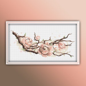 Op de afbeelding: Een aquarel van een magnolia tak met roze bloemen en bruine takken. Het schilderij is ingelijst in een wit frame.