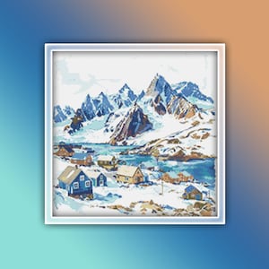 Pu&ograve; includere: Uno schema di punto croce che raffigura un paesaggio montano innevato con un piccolo villaggio di case blu e marroni incastonato nella valle. Le montagne sono ricoperte di neve e il cielo &egrave; di un azzurro chiaro.